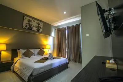 a bedroom with a bed and a tv on the wall at Abisha Villa Jimbaran in Jimbaran