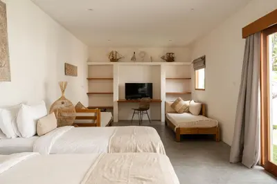 a hotel room with two beds and a television at Villa Folie by Alfred in Bali in Seminyak