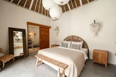 a bedroom with a large bed and a mirror at Villa Folie by Alfred in Bali in Seminyak