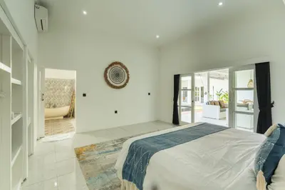 a white bedroom with a bed and a living room at Modern 3 Bedrooms Villa Beach Walking Distance in Seminyak