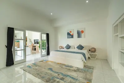 a white bedroom with a bed and a rug at Modern 3 Bedrooms Villa Beach Walking Distance in Seminyak