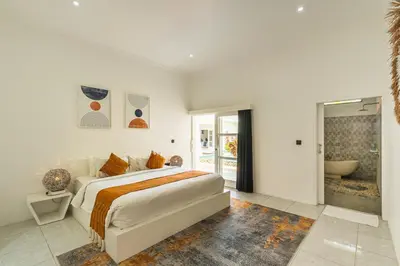 a bedroom with a large bed and a bathroom at Modern 3 Bedrooms Villa Beach Walking Distance in Seminyak