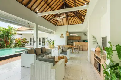 an open living room with white furniture and a swimming pool at Modern 3 Bedrooms Villa Beach Walking Distance in Seminyak