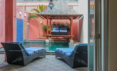 a swimming pool with two chairs and a gazebo at 5 Bedroom Getaway Villa - Kuta Regency B3 in Kuta