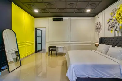 a bedroom with a white bed and a yellow wall at Villa Canberra - Seminyak in Seminyak