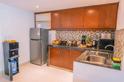 a kitchen with wooden cabinets and a stainless steel refrigerator at Alam Jepun Villa in Legian
