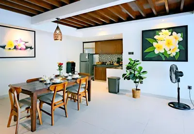a kitchen and dining room with a wooden table and chairs at Alam Jepun Villa in Legian