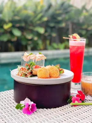 a plate of food on a table with a drink at INSPIRA Seminyak in Seminyak