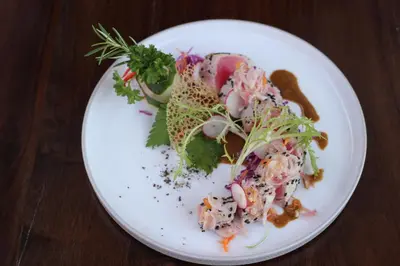 a white plate with a salad on a table at INSPIRA Seminyak in Seminyak