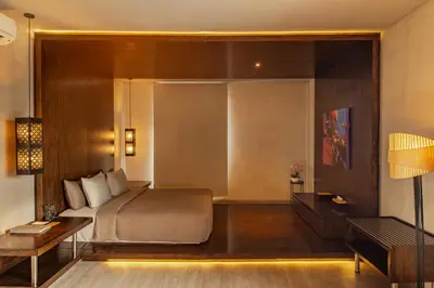 a bedroom with a bed and a table and a desk at INSPIRA Seminyak in Seminyak