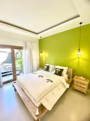 a bedroom with a large bed with a green wall at NEW Villa Indah Seminyak 3BR Private Pool in Seminyak