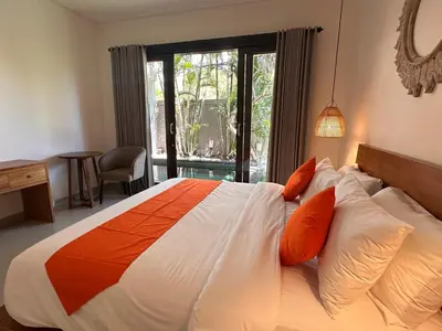 a bedroom with a large bed with orange and white pillows at NEW Villa Indah Seminyak 3BR Private Pool in Seminyak