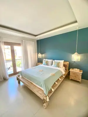 a bedroom with a large bed with a blue wall at NEW Villa Indah Seminyak 3BR Private Pool in Seminyak