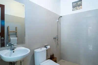 a white bathroom with a sink and a toilet at Villa Kori Bali Kubu, 9 people maximum, close to Seminyak Beach in Seminyak