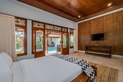 a bedroom with a bed and a tv in a room at Villa Kori Bali Kubu, 9 people maximum, close to Seminyak Beach in Seminyak