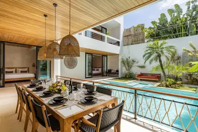 a dining room with a table and chairs next to a pool at Premium 5 bd Luxury Central Villa 300m to beach & Ku De Ta in Seminyak