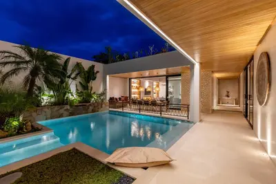 an indoor pool in a house at night at Premium 5 bd Luxury Central Villa 300m to beach & Ku De Ta in Seminyak