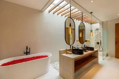 a bathroom with a tub and a sink and mirrors at Premium 5 bd Luxury Central Villa 300m to beach & Ku De Ta in Seminyak