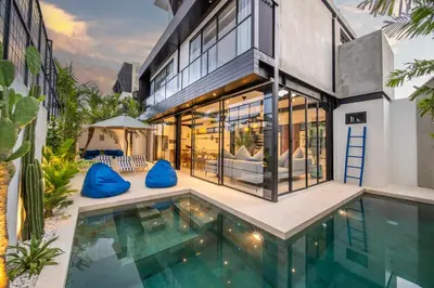 an exterior view of a house with a swimming pool at Villa Vantage Canggu in Canggu