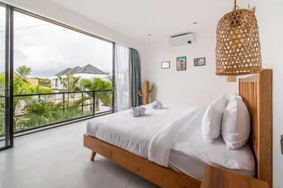 a bedroom with a bed and a large window at Villa Vantage Canggu in Canggu