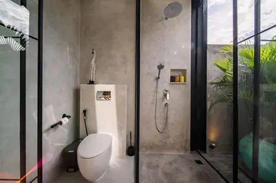 a bathroom with a shower with a toilet and a glass shower stall at Villa Vantage Canggu in Canggu