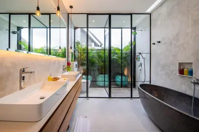 a bathroom with a large tub and a sink and a bath tub at Villa Vantage Canggu in Canggu