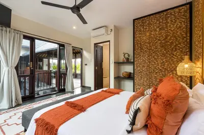 a woman laying on a bed in a bedroom at Villa Suvitha by Villa Finder in Seminyak