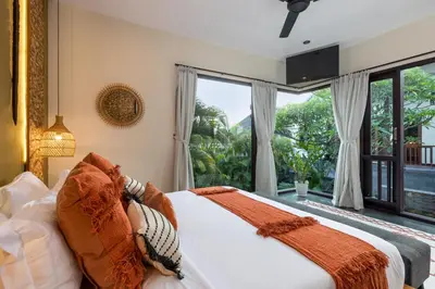 a bedroom with a bed and a large window at Villa Suvitha by Villa Finder in Seminyak