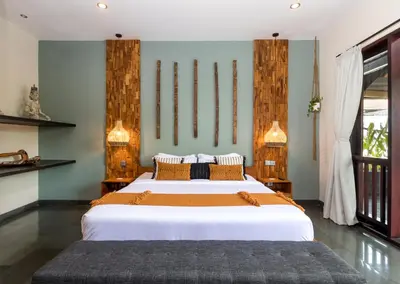a bedroom with a large bed with white sheets at Villa Suvitha by Villa Finder in Seminyak
