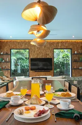 a wooden table with food and drinks on it at Villa Suvitha by Villa Finder in Seminyak