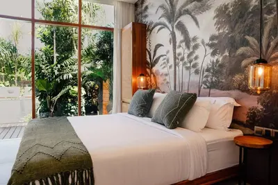 a bedroom with a white bed with a large window at Luxury 5bd Villa 5 Min From Berawa Beach in Canggu