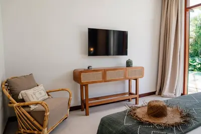 a living room with a tv and a chair at Luxury 5bd Villa 5 Min From Berawa Beach in Canggu