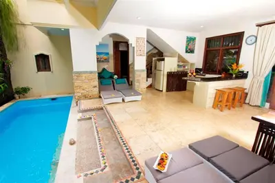 a living room with a swimming pool and a kitchen at Largest Villa in Kuta Royal C1 - Turquoise Villa in Kuta