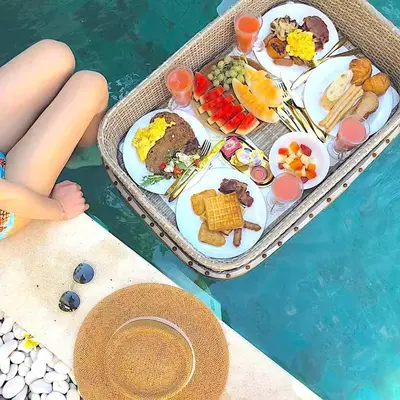 a tray of food on a table next to a swimming pool at Villa Seminyak - 2bdr private big pool villa in Seminyak