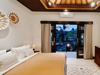 a bedroom with a bed and a sliding glass door at Villa Sriwedari - Seminyak in Seminyak
