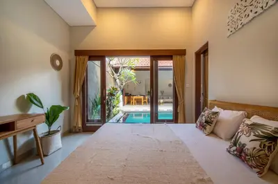 a bedroom with a bed and a pool at [Seminyak central] private 3 bedrooms villa with swimming pool in Seminyak