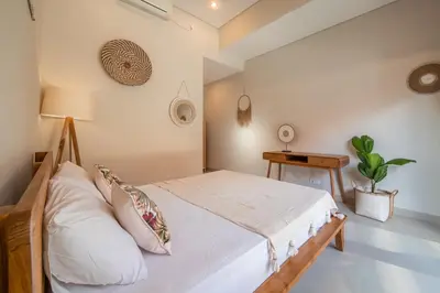 a bedroom with a bed and a lamp and a table at [Seminyak central] private 3 bedrooms villa with swimming pool in Seminyak