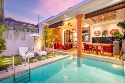 a house with a swimming pool and a dining area at Villa Lollie Seminyak in Seminyak