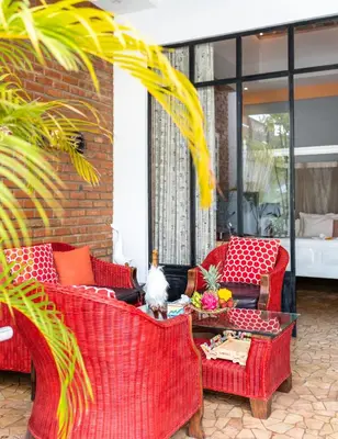 a patio with red wicker chairs and a table at Villa Lollie Seminyak in Seminyak