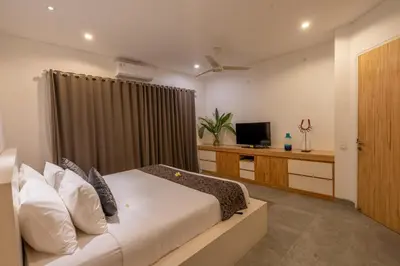 a hotel room with a bed and a television at Villa Becca Seminyak by Best Deals Asia Hospitality in Seminyak