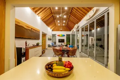 a kitchen and living room with a bowl of fruit on a counter at Villa Becca Seminyak by Best Deals Asia Hospitality in Seminyak
