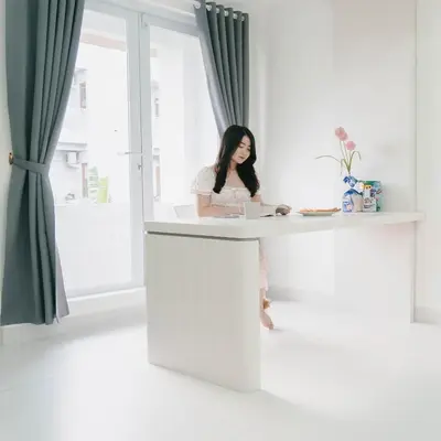 a woman sitting at a desk with a laptop at The Axara Bali Managed by ARM Hospitality in Nusa Dua