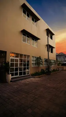 a large building with a sunset in the background at The Axara Bali Managed by ARM Hospitality in Nusa Dua