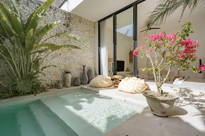 a swimming pool in a room with plants at Casa Noema in Kerobokan