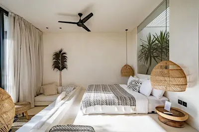 a bedroom with a bed and a ceiling fan at Casa Noema in Kerobokan