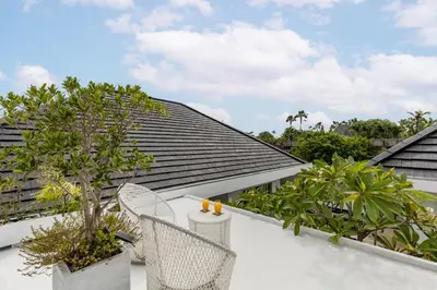 a balcony with chairs and trees on a roof at Fresh and Stylish 3bd Villa in Seminyak with Private Pool in Seminyak