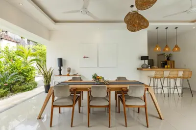 a kitchen and dining room with a wooden table and chairs at Fresh and Stylish 3bd Villa in Seminyak with Private Pool in Seminyak