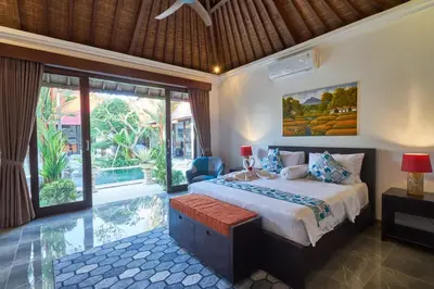 a bedroom with a bed and a large window at Villa Bulan Batubelig in Canggu