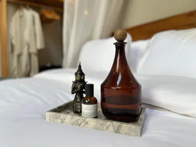 a bottle sitting on top of a bed at Rumah Ananda Bali - Balinese Villa Umalas in Canggu