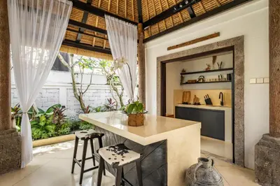an open kitchen with a counter and stools at Rumah Ananda Bali - Balinese Villa Umalas in Canggu